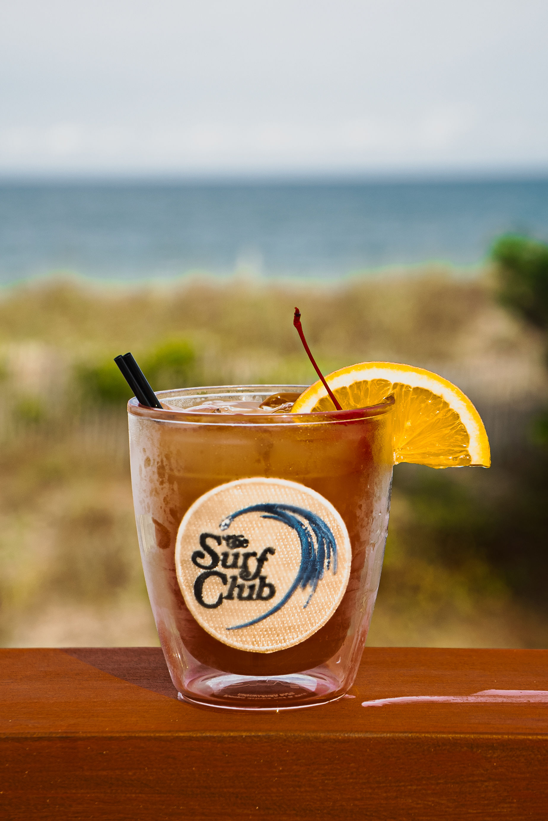 A signature Surf Club cocktail garnished with orange and cherry