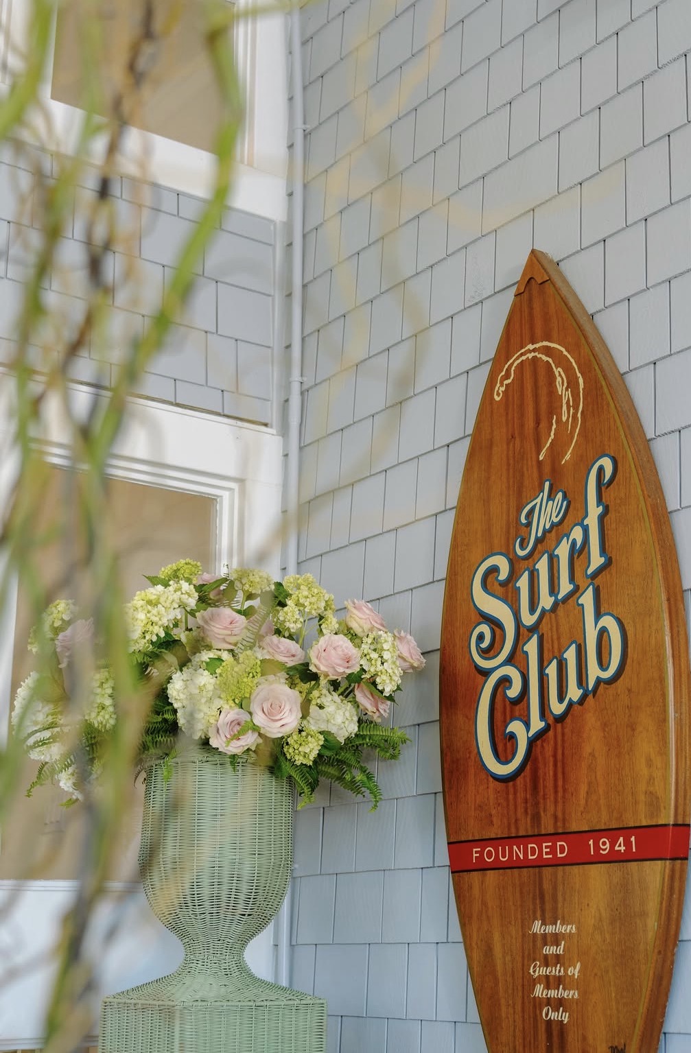 The Surf Club's carved surfboard sign — Founded 1941